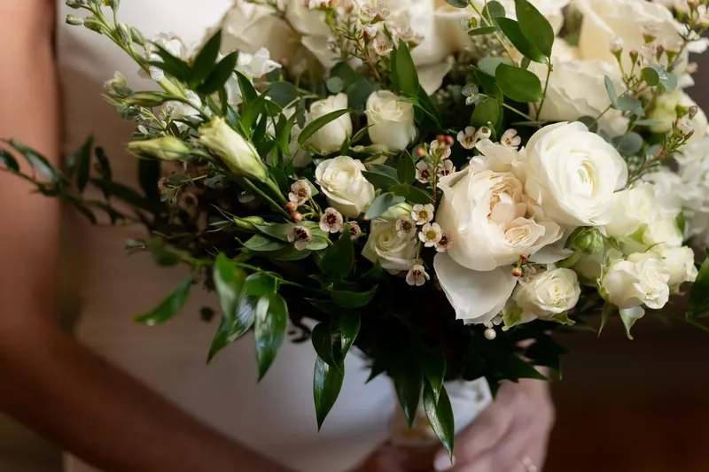 Close-up of white roses and greenery arranged in Kimberly's bridal bouquet.