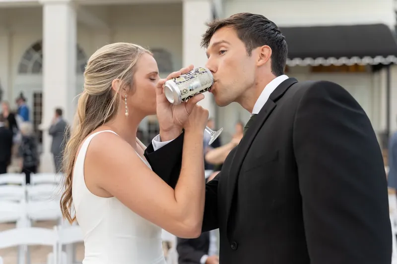 Kimberly and Landon share a champagne toast, with Kimberly raising a glass to her lips while Landon watches.
