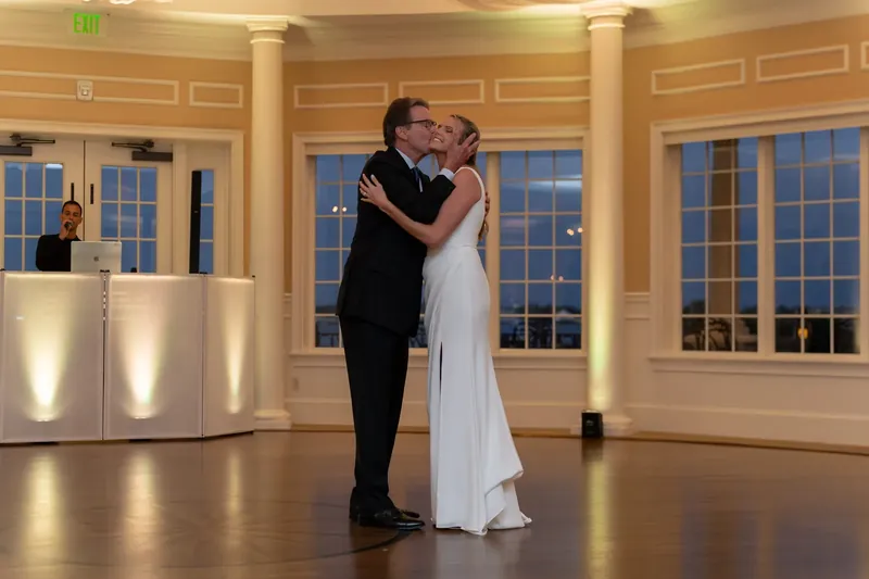 Landon and Kimberly embrace and kiss on the dance floor beneath draped fabric and warm lighting.