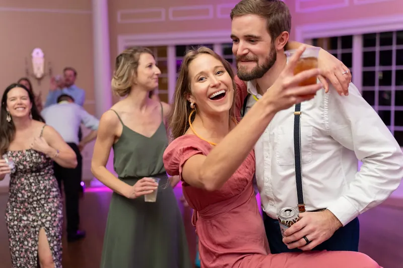 Landon wraps an arm around Kimberly as she laughs and points during their first dance.
