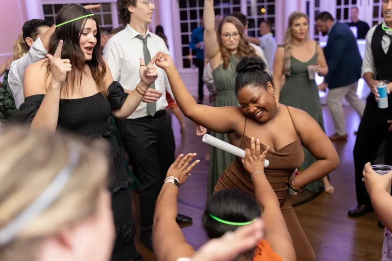 Kimberly dances with guests on the ballroom floor, smiling broadly in her brown strapless gown.