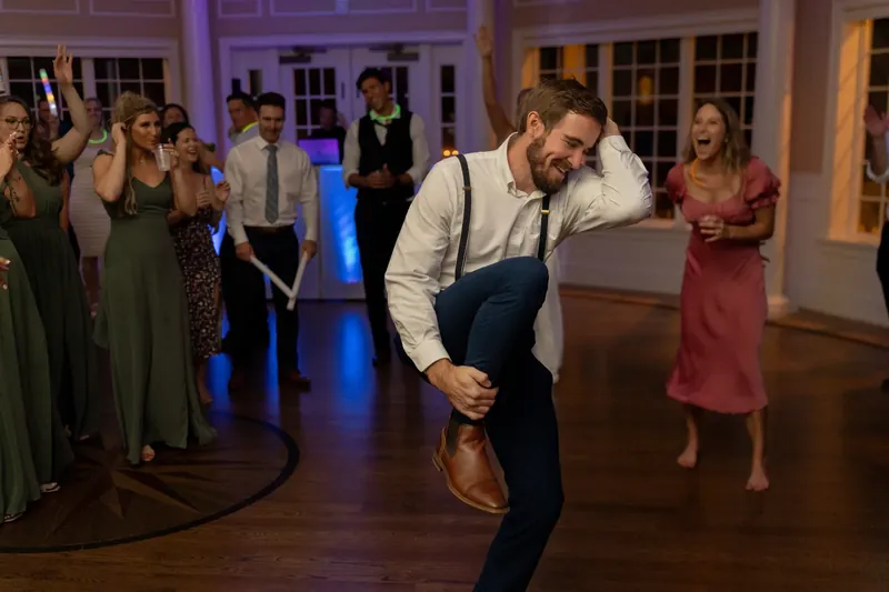 Landon grooves solo on the dance floor while guests watch and cheer him on.