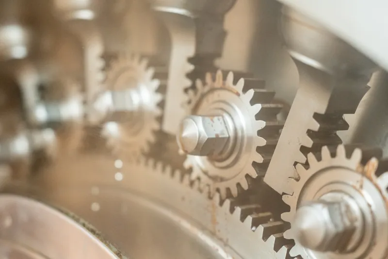 Metallic decorative gears mounted on a wall at The Treasury on the Plaza catch soft light in sharp focus.