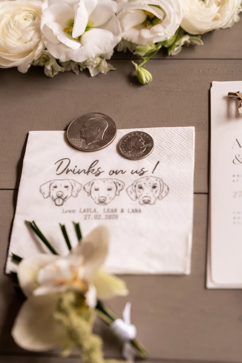 Custom Drinks on us cocktail napkin with Layla, Leah, and Lana dog illustrations, coins, and flowers