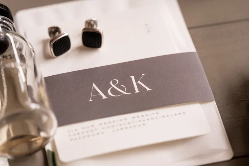 A&K monogram wedding stationery with black cufflinks and cologne