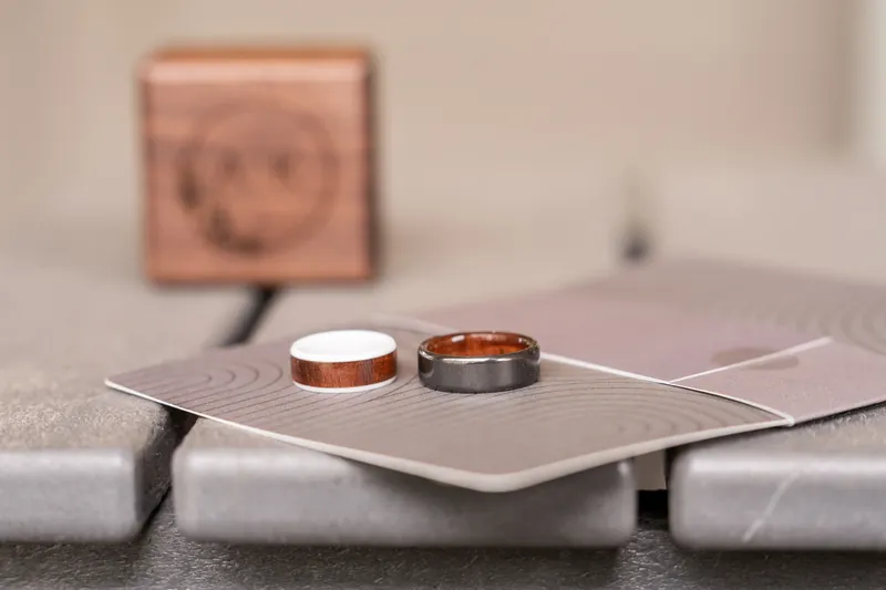 Wood-inlay and gunmetal wedding rings on stationery