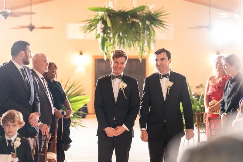 Austin and Kirkland entering the ceremony together as guests look on