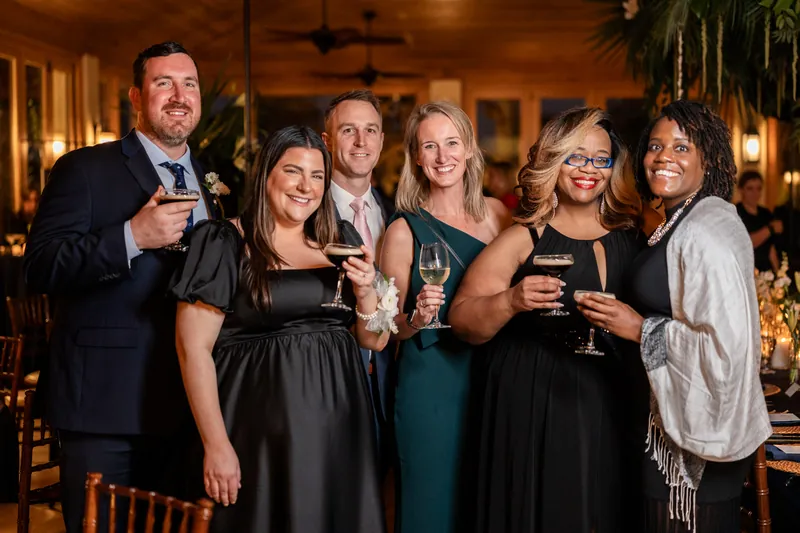 Group of guests smiling with cocktails during the reception