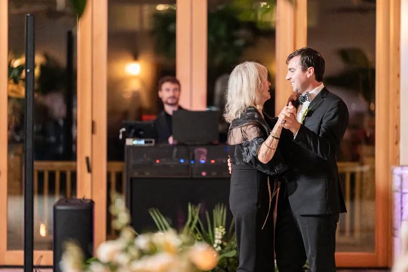 Parent dance with groom and his mother dancing with DJ in the background