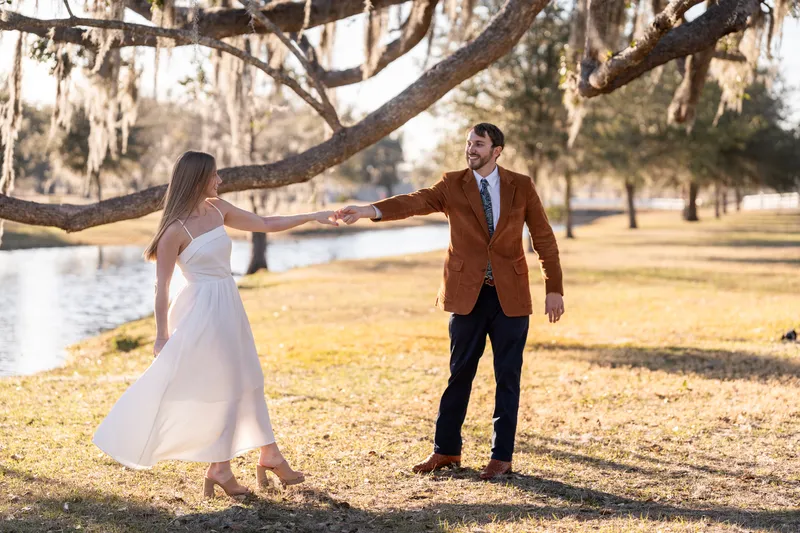 Lacey twirling under a live oak draped in Spanish moss with the pond behind them