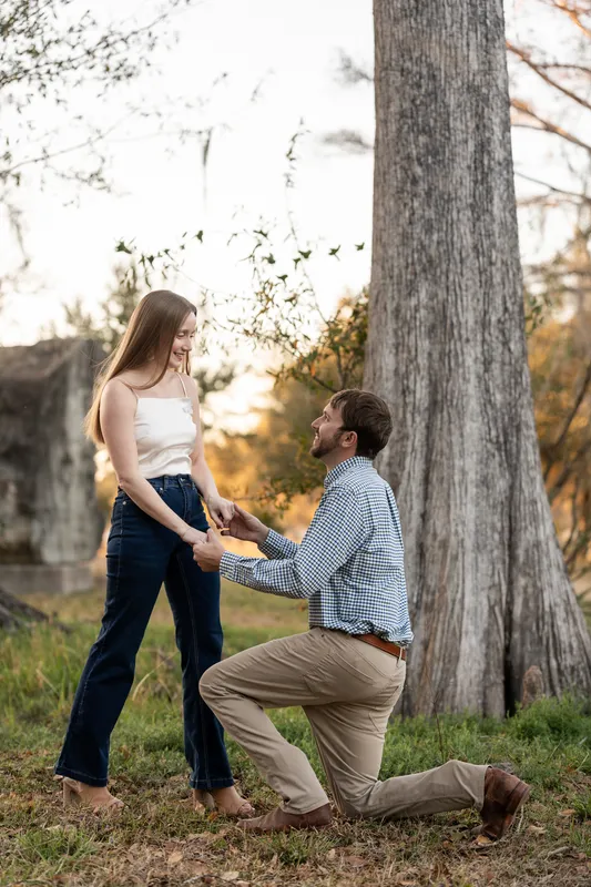 Josh on one knee recreating his proposal at Congaree and Penn
