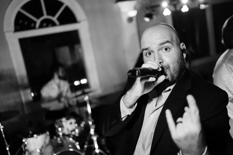 Jake speaks animatedly into a microphone during his reception speech in black and white.
