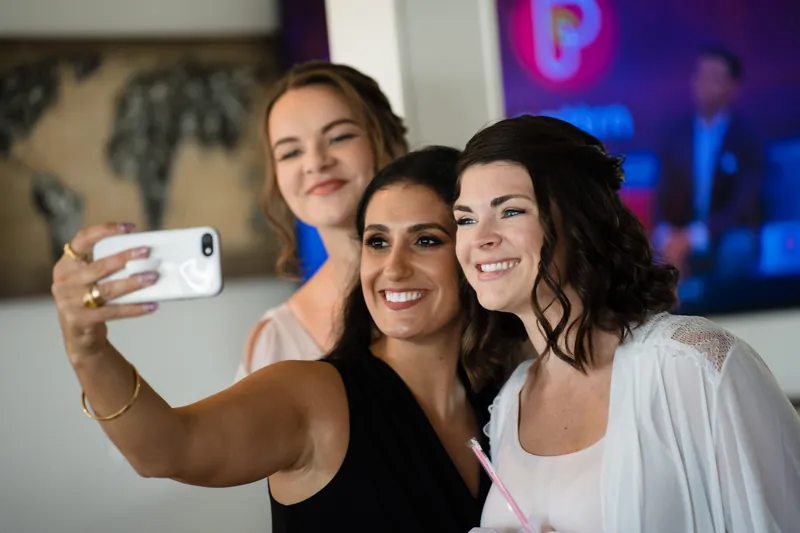 Three women take a selfie together at The White Room, smiling at the camera.