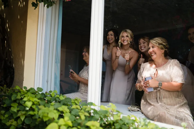 Guests watch and applaud from the doorway as the couple celebrates outside.