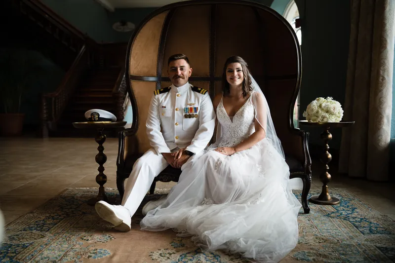 Laurel and Jake sit together under an arched doorway at The White Room, holding hands and gazing at each other.