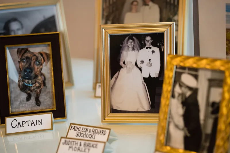 Framed vintage wedding photographs and memorabilia displayed on white surfaces at The White Room.