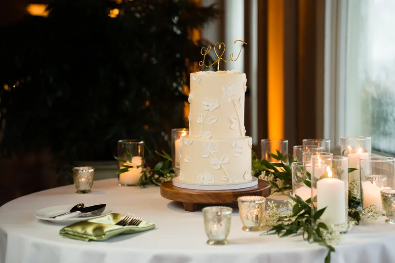 Two champagne flutes clink together with warm golden lights bokeh in the background during the reception.