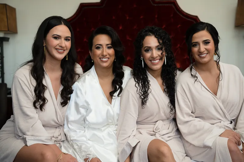 Four women in white robes smile together in an ornate room at the Cathedral Basilica of St. Augustine.