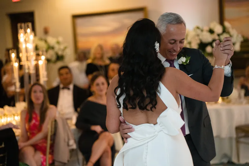 Cole spins Lehna during their dance as seated guests look on at the reception.