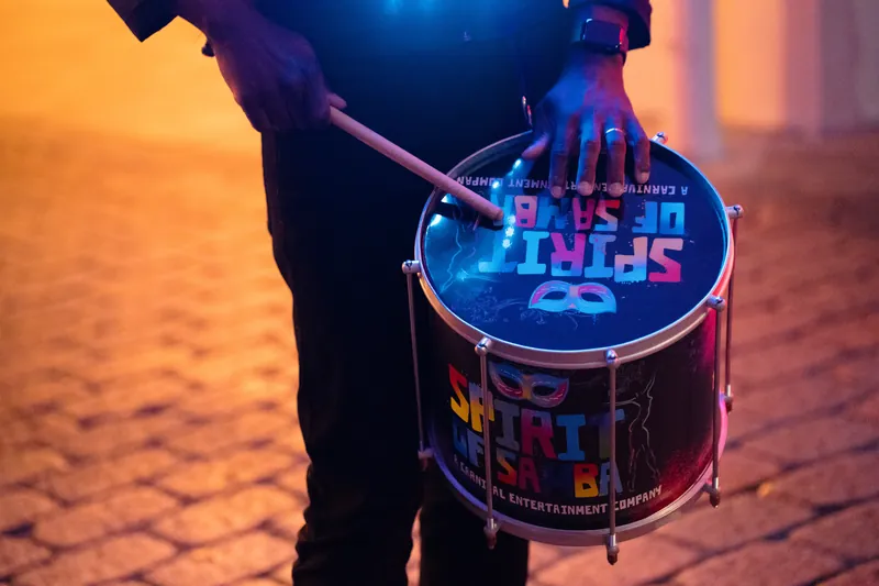 Hands hold a glowing blue neon sign during an evening celebration at the reception.