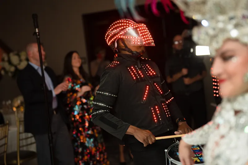 Performers wearing elaborate feathered and jeweled costumes entertain at the reception.