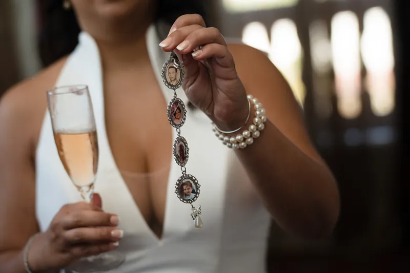 Lehna holds a champagne flute and displays an ornate gemstone necklace at the Cathedral Basilica of St. Augustine.