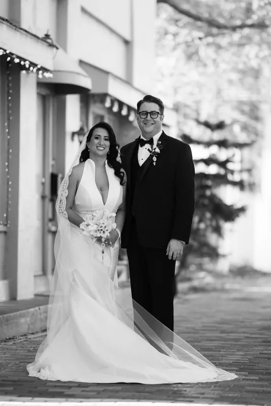 Lehna and Cole pose together on the Casa Monica Resort & Spa's terrace, she in a flowing white gown with veil and he