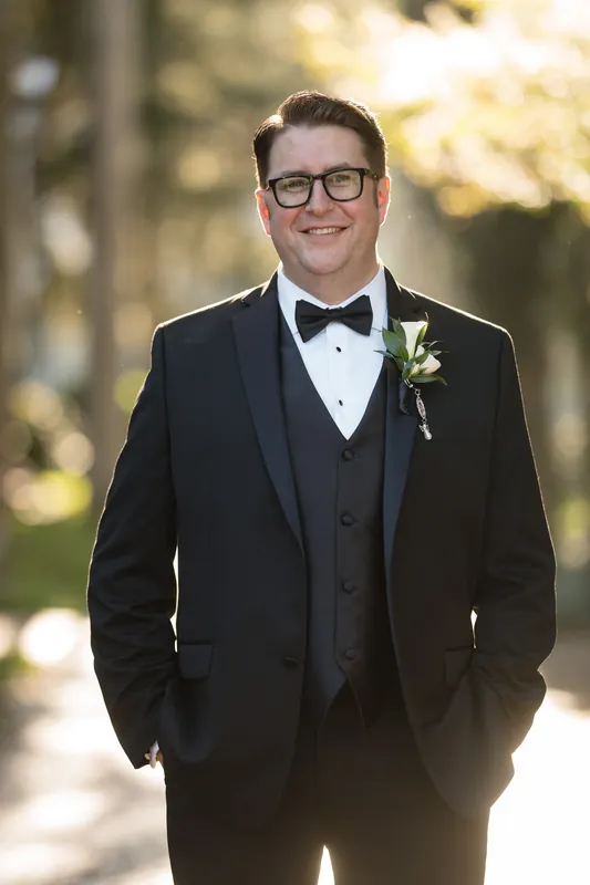 Cole stands in formal black-tie attire with a boutonnière at Casa Monica Resort & Spa.