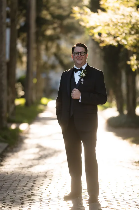 Cole walks a tree-lined pathway in his tuxedo at Casa Monica Resort & Spa.