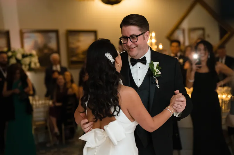 Cole and Lehna embrace during a slow dance surrounded by wedding guests at their reception.