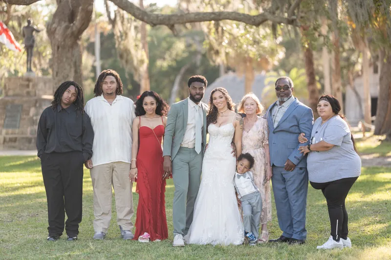 Lena and Blake pose with nine family members under Spanish moss-draped oaks at Fountain of Youth Archaeological Park, all
