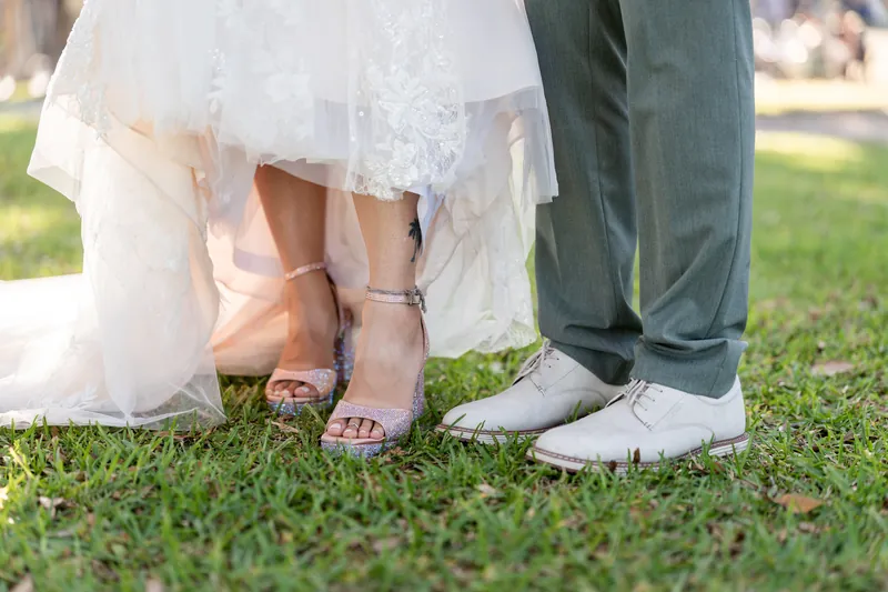 Lena's beaded wedding dress and train drape across the grass as she and Blake show off their coordinated footwear