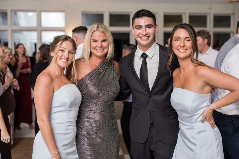 Four people in formal wedding attire smile together indoors at The Preserve at Amelia River Club.