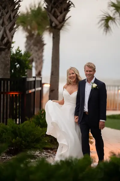 St. Augustine wedding photographer captures couple walking among palm trees at Embassy Suites Beach