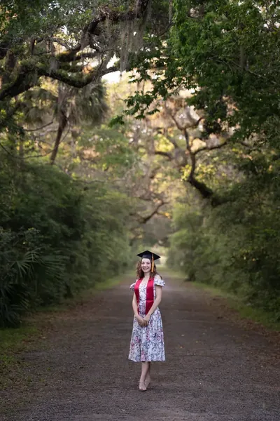 Lydia in graduation cap under oak tree canopy at Washington Oaks