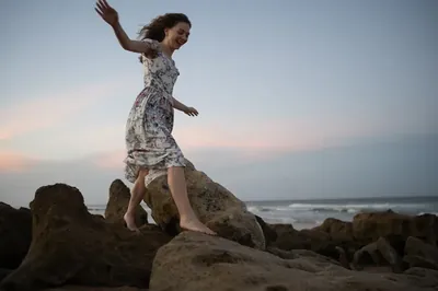 Lydia climbing beach rocks at sunset