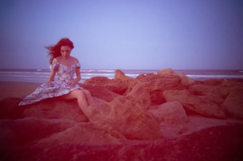 Lydia on beach rocks with lo-fi vintage effect