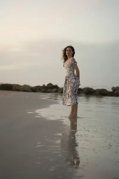 Lydia standing in shallow water at beach