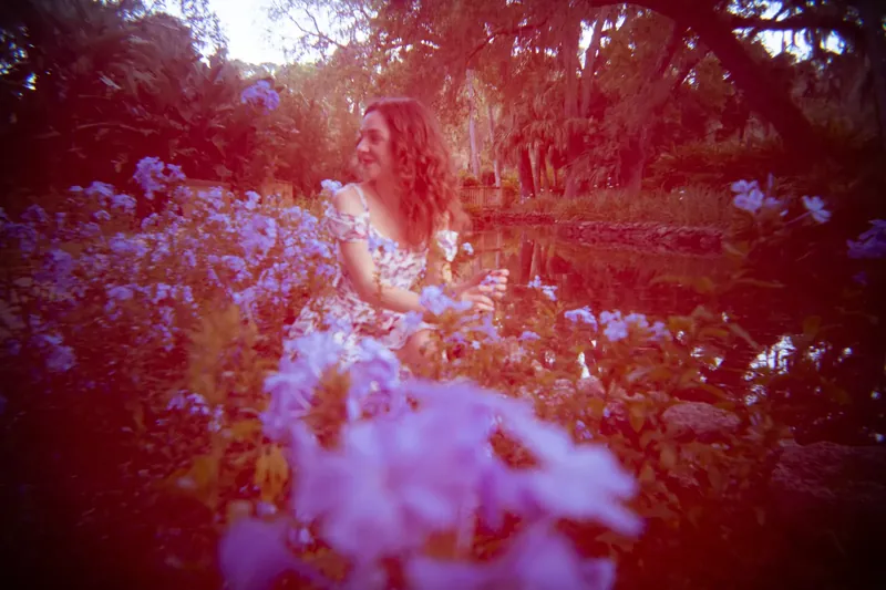 Lydia by pond with plumbago flowers lo-fi lens