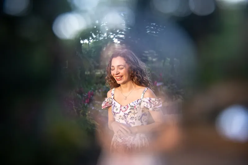 Lydia laughing in garden with dreamy bokeh