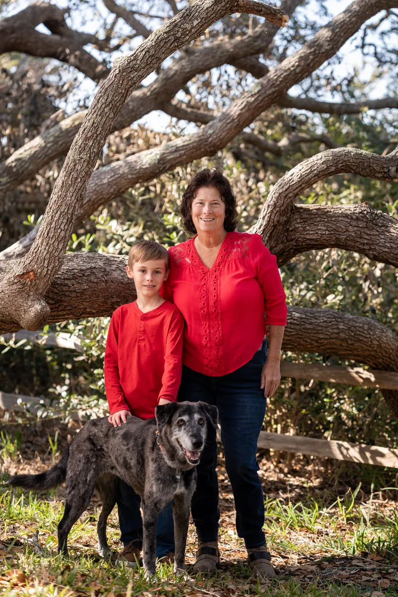 Grandmother with grandson and the family dog under the oak tree