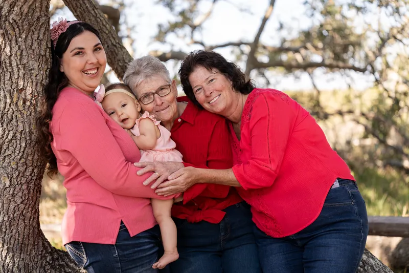 Three generations of women holding the baby under the oak trees