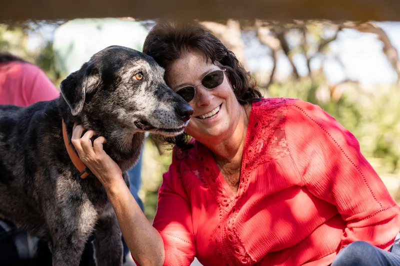 Woman getting a kiss from the family dog at Nease Park