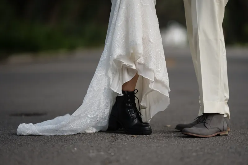 Detail shot of bride's black boots and lace dress hem