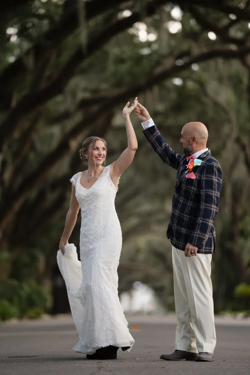 Groom spinning bride under oak trees