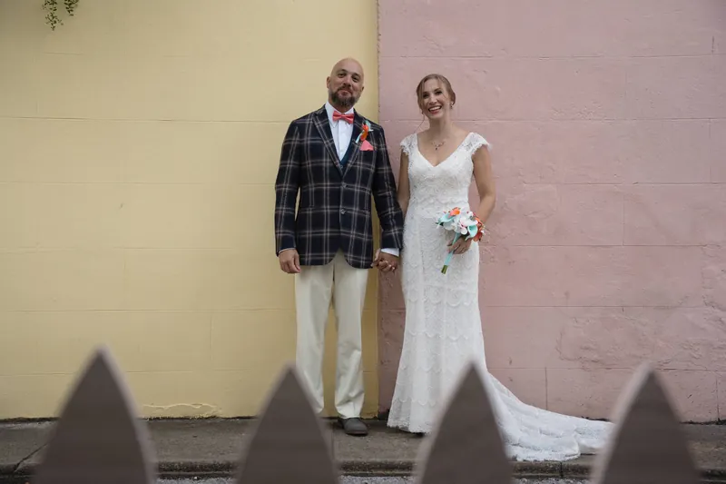 Couple standing by colorful yellow and pink walls downtown