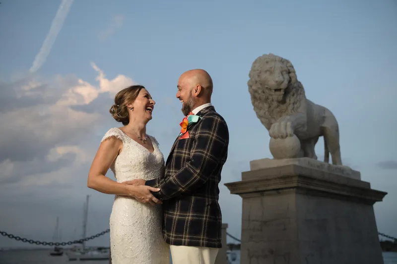 Couple laughing together with lion statue at Bridge of Lions
