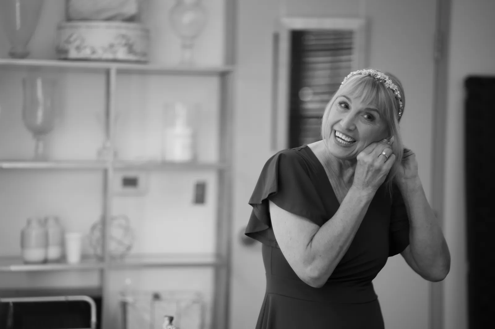 Marlene getting ready putting on earrings black and white wedding photo
