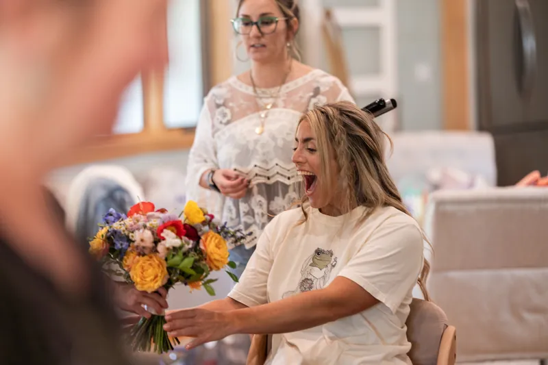 Bride reacting to seeing her colorful wildflower bouquet during getting ready