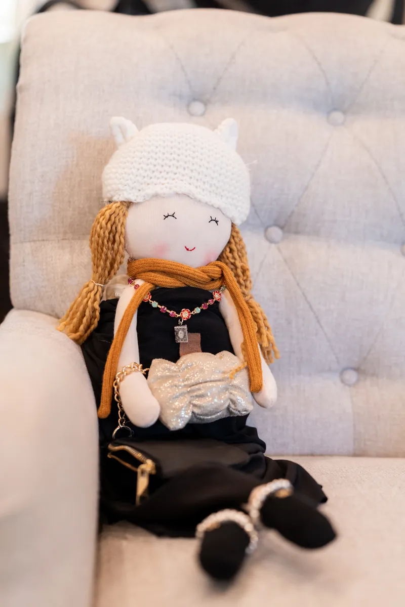 Sentimental doll dressed in lace sitting on chair with wedding dress